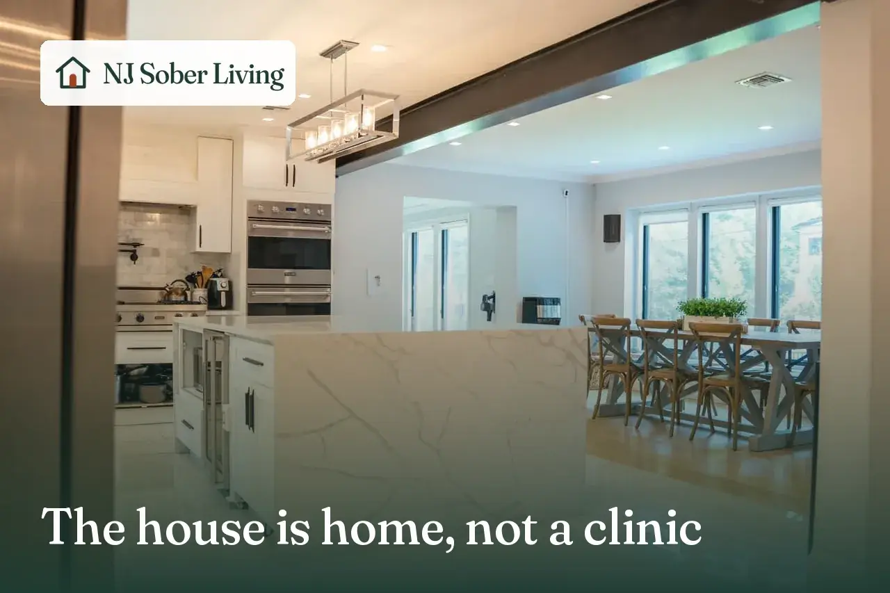 What the house handles and what treatment handles in Closter, NJ: the Closter Residence I kitchen, with the NJ Sober Living logo and "The house is home, not a clinic" text