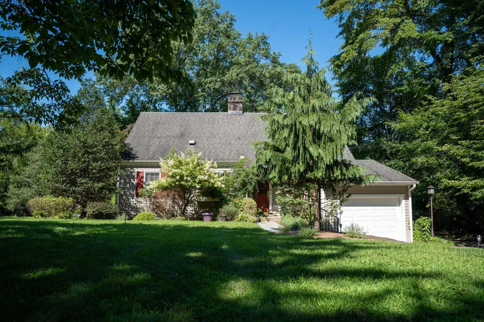 Closter Residence II seen across its front lawn, under tall trees