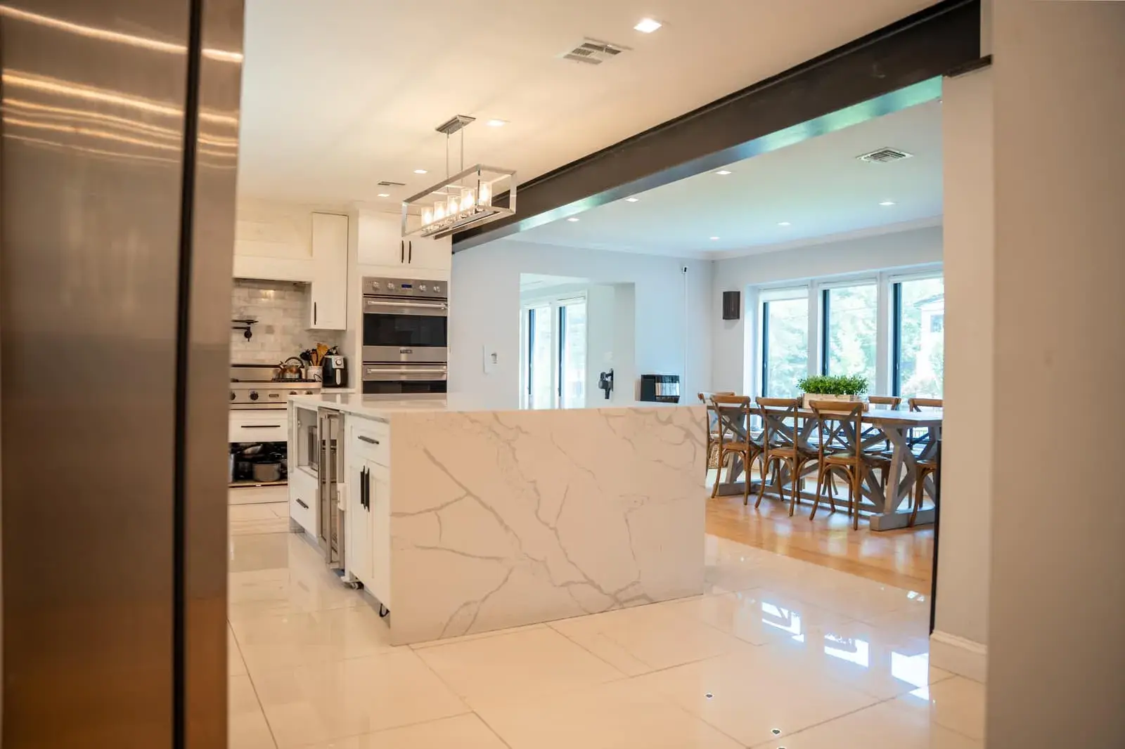 Shared kitchen with an island and a long dining table in a Closter sober residence, where housemates cook and sit down to meals together