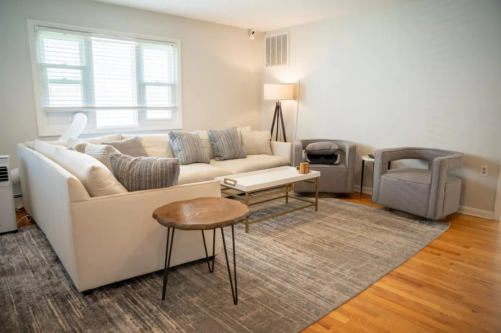 The living room at the Waldwick house: a large sectional sofa, two armchairs and a coffee table on a rug